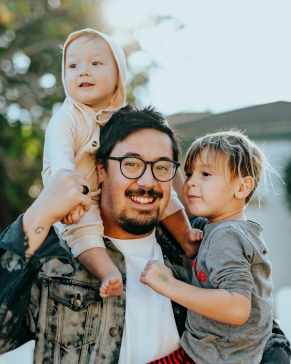 A smiling parent spending time outdoors with his children